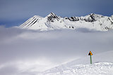 Warning sing on ski slope and mountains in fog