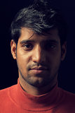 Portrait of young Indian man over dark