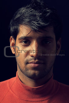 Portrait of young Indian man over dark
