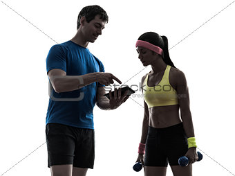 woman exercising fitness  man coach using digital tablet silhoue