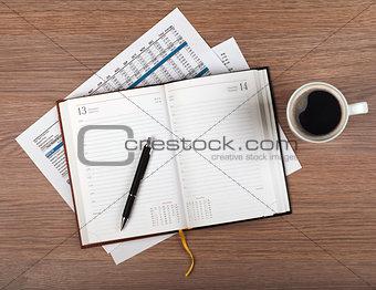 Notepad and coffee cup on wood table