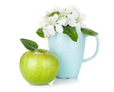 Ripe green apple and flowers in cup