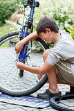 Teenager repairing his bike, changing broken tyre