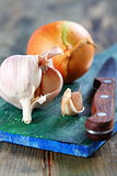 Garlic and onions on a cutting board.