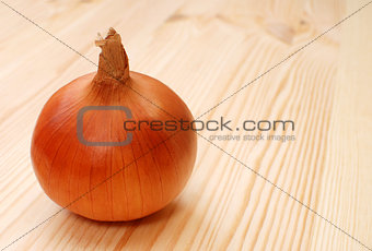 Whole white onion on a wooden table