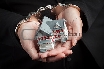 Woman In Handcuffs Holding Small House