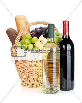 Picnic basket with bread, cheese, grape and wine bottles