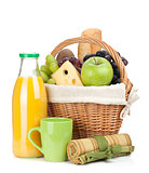 Picnic basket with bread, fruits and orange juice bottle