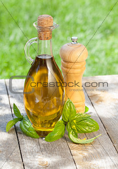 Olive oil bottle, pepper shaker and basil