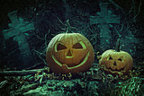 Halloween pumpkins in graveyard at night