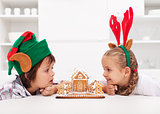 Kids with funny christmas hats and gingerbread house