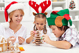 Happy family making a gingerbread cookie christmas tree