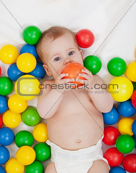 Chubby baby girl playing with colorful balls