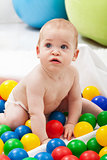 Baby boy playing with colorful plastic balls