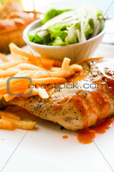 Chicken with sauce and golden French fries