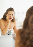 Woman having toothache in bathroom