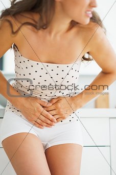 Closeup on woman having stomachache in bathroom
