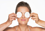 Woman holding cotton pads in front of eyes