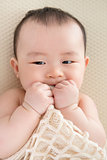 Teething Asian baby girl 