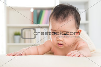 Asian baby girl crawling on be
