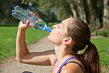 Attractive woman drinking water after sports