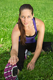Woman making stretching exercise before sports on a meadow