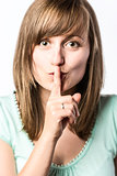 Young woman holds a finger to her mouth