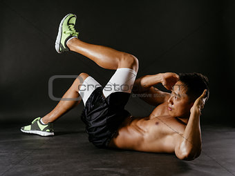Asian man exercising his stomach muscles