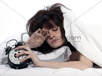 woman in bed awakening tired holding alarm clock