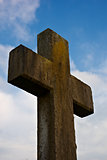 Graveyard cross against blue sky