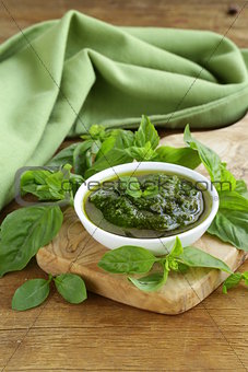 pesto sauce with basil and olive oil on a wooden table