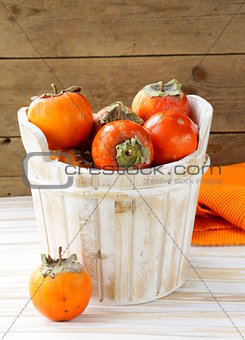 Orange ripe persimmon in a wooden table