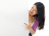 Asian woman pointing to blank billboard. 