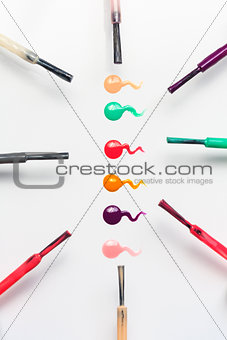 Set of multicolored nail polish brushes and drops