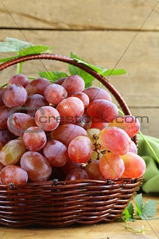 ripe red organic grapes in a basket on a wooden table