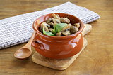 mushroom ragout of champignons and basil on a wooden table