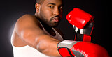 African American Male Puncher Hits Heavy Bag with Red Boxing Gloves