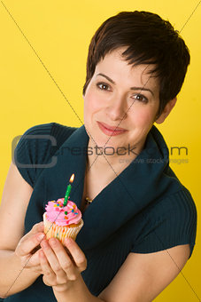 Pretty Woman Holds Birthday Cupcake One Candle Yellow Background