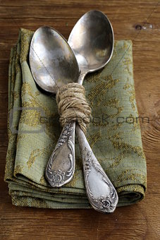 vintage silver cutlery on a wooden background
