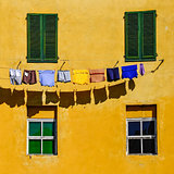 Detail of colorful yellow house walls, windows and clothes