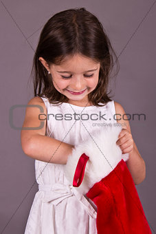 Little girl getting a gift from her Christmas stocking