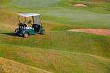 Green golf cart on the empty golf course