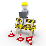 Under construction sign and a worker with laptop