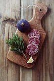 Salami, fig and rosemary on a chopping board