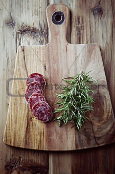 Salami and rosemary on a kitchen board