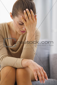 Stressed young housewife sitting on couch