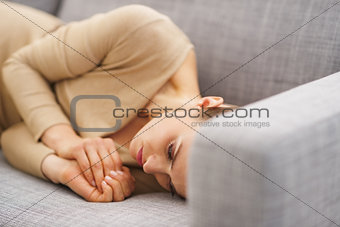 Frustrated young housewife laying on couch