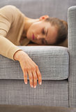 Closeup on hand of frustrated young housewife laying on sofa