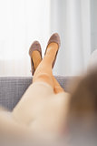Closeup on leg of young housewife laying on sofa