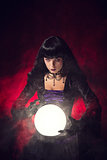 Beautiful gothic style fortune teller with a crystal ball 